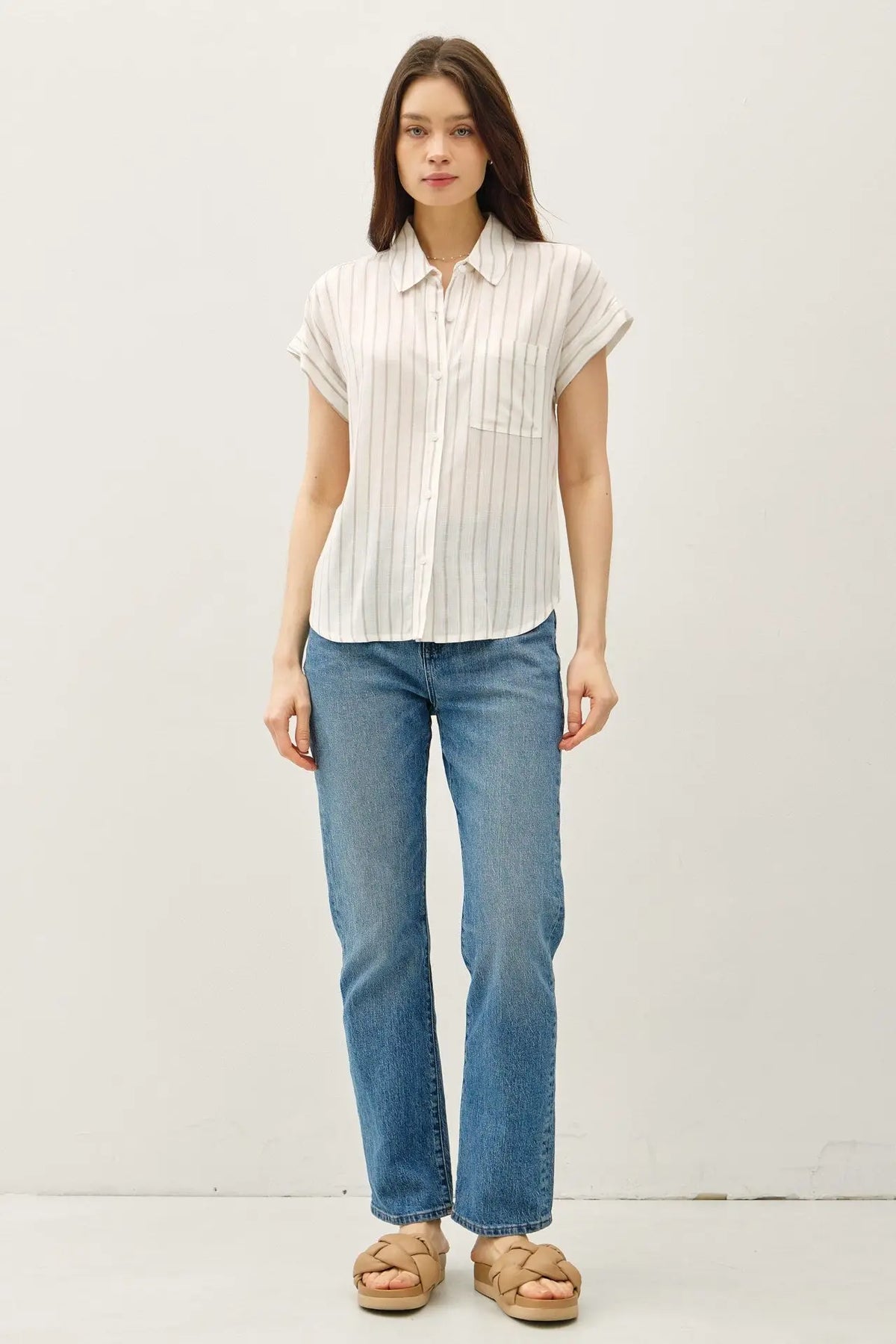 Woman wearing a stylish short sleeve striped shirt and jeans outfit showcasing the SHORT SLEEVE STRIPED SHIRT
