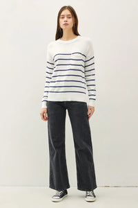 Woman wearing a stylish lightweight striped sweater with dark jeans outfit