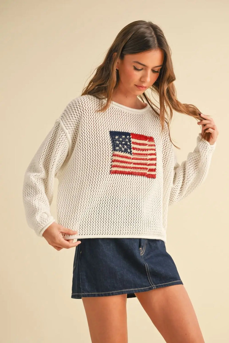Woman’s white knit sweater with American flag, perfect for women’s boho chic clothing at Shop Daisy