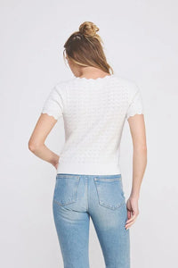 Woman wearing a Pointelle V-Neck Knit Top with scallop edges and blue jeans