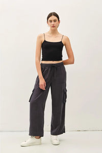 Women’s black spaghetti strap crop top paired with high rise drawstring wide leg cargo pants