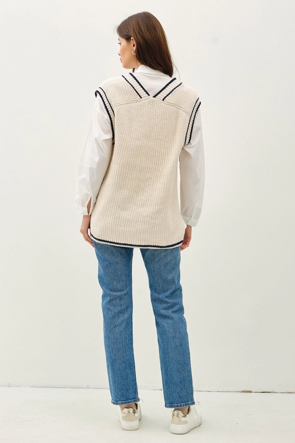 Women’s cream-colored ribbed knit sweater vest with black accent stripe in varsity style