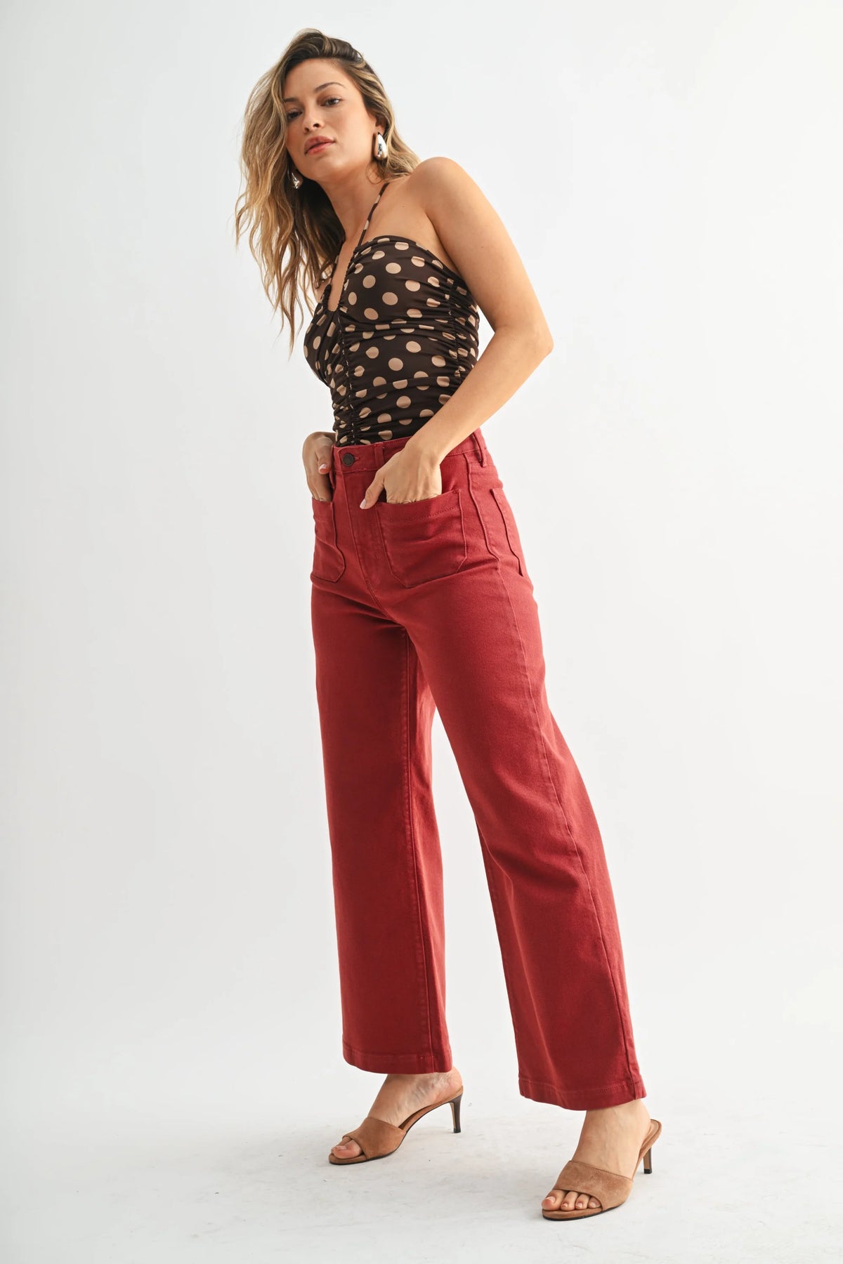 Women’s dark brown polka dot halter top with high-waisted brick red wide-leg denim jeans featuring patch pockets