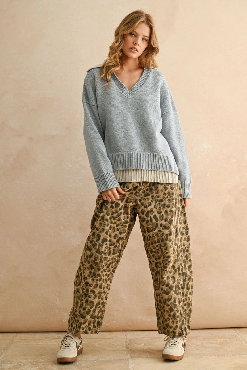 Women’s light blue color combo V-neck sweater layered over a lighter top with leopard print pants