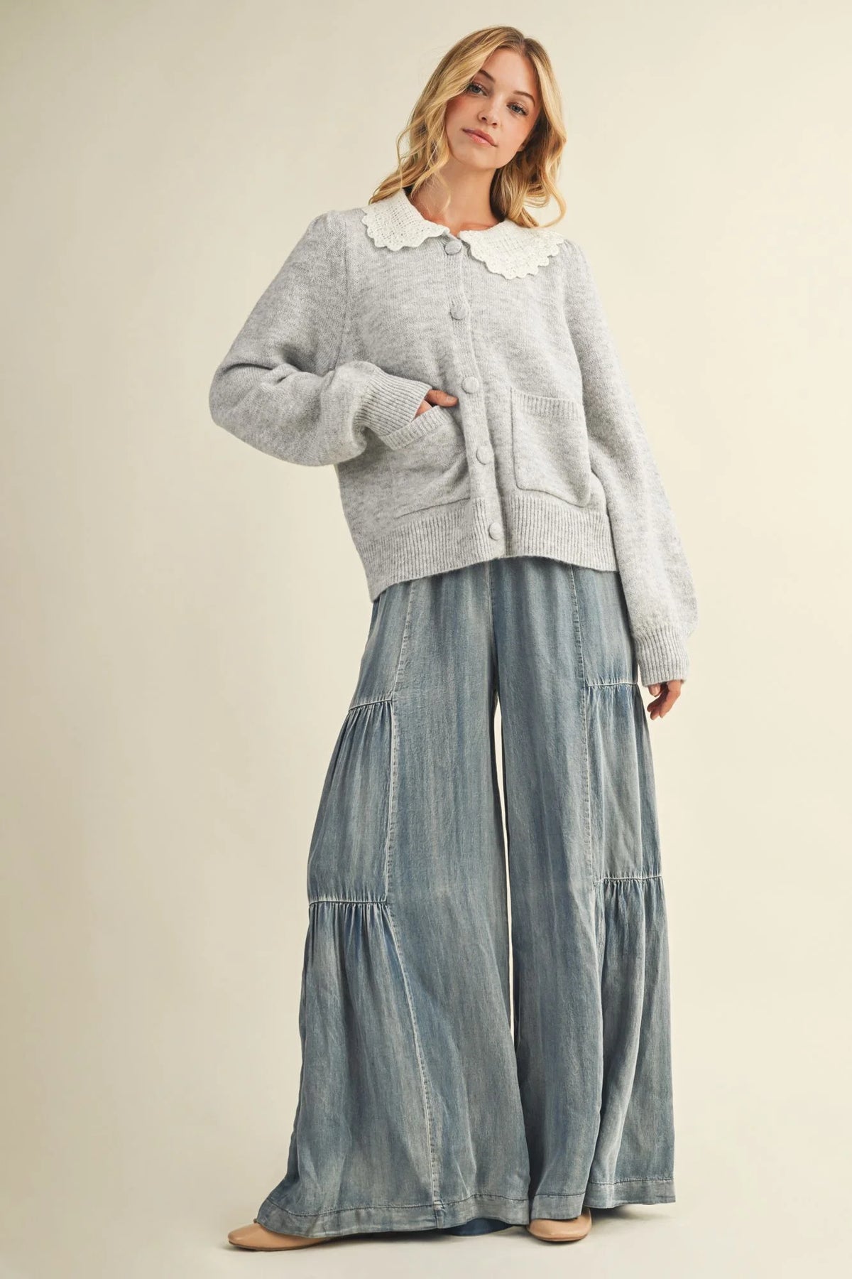 Women’s light grey button-up cardigan with white scalloped collar paired with washed denim wide pants