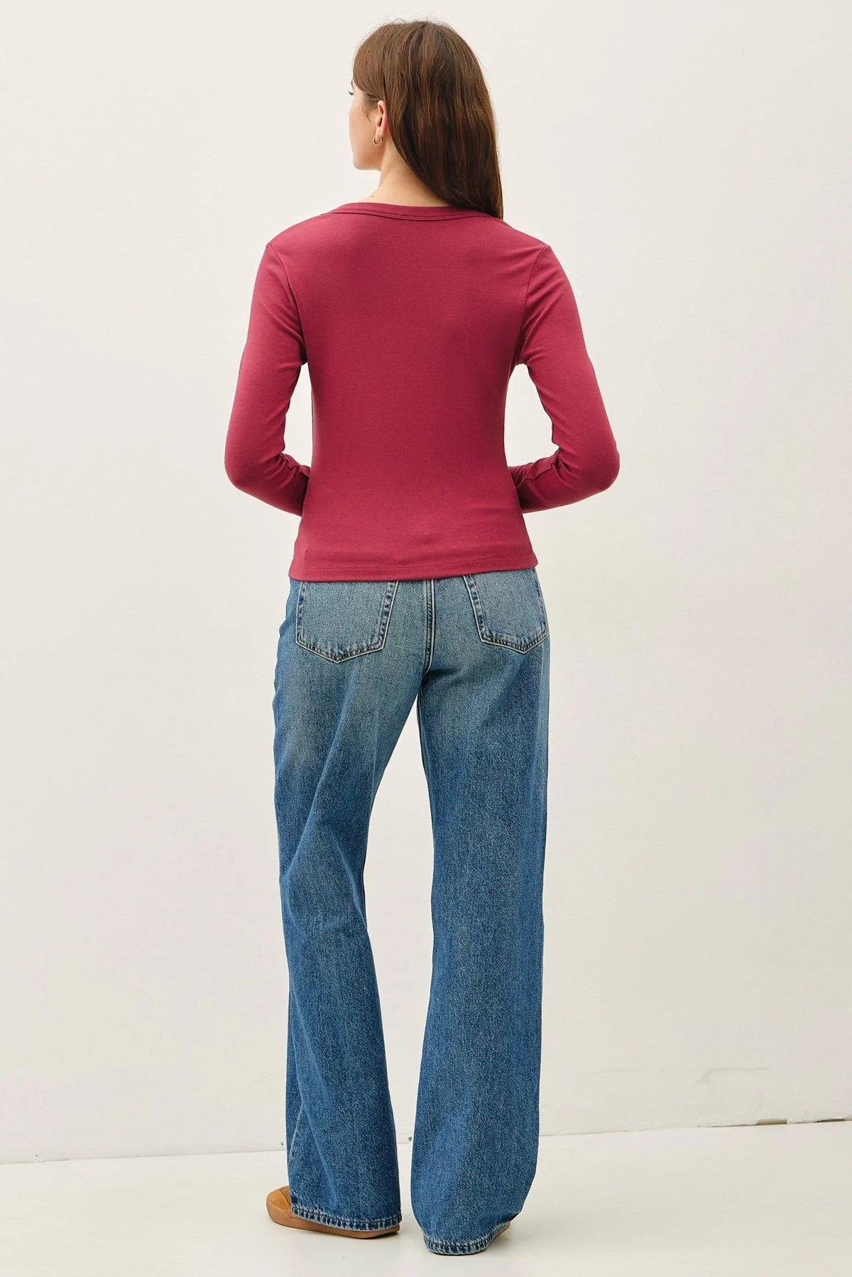 Women’s magenta scoop neck long sleeve top with wide-leg blue jeans, stylish casual wear