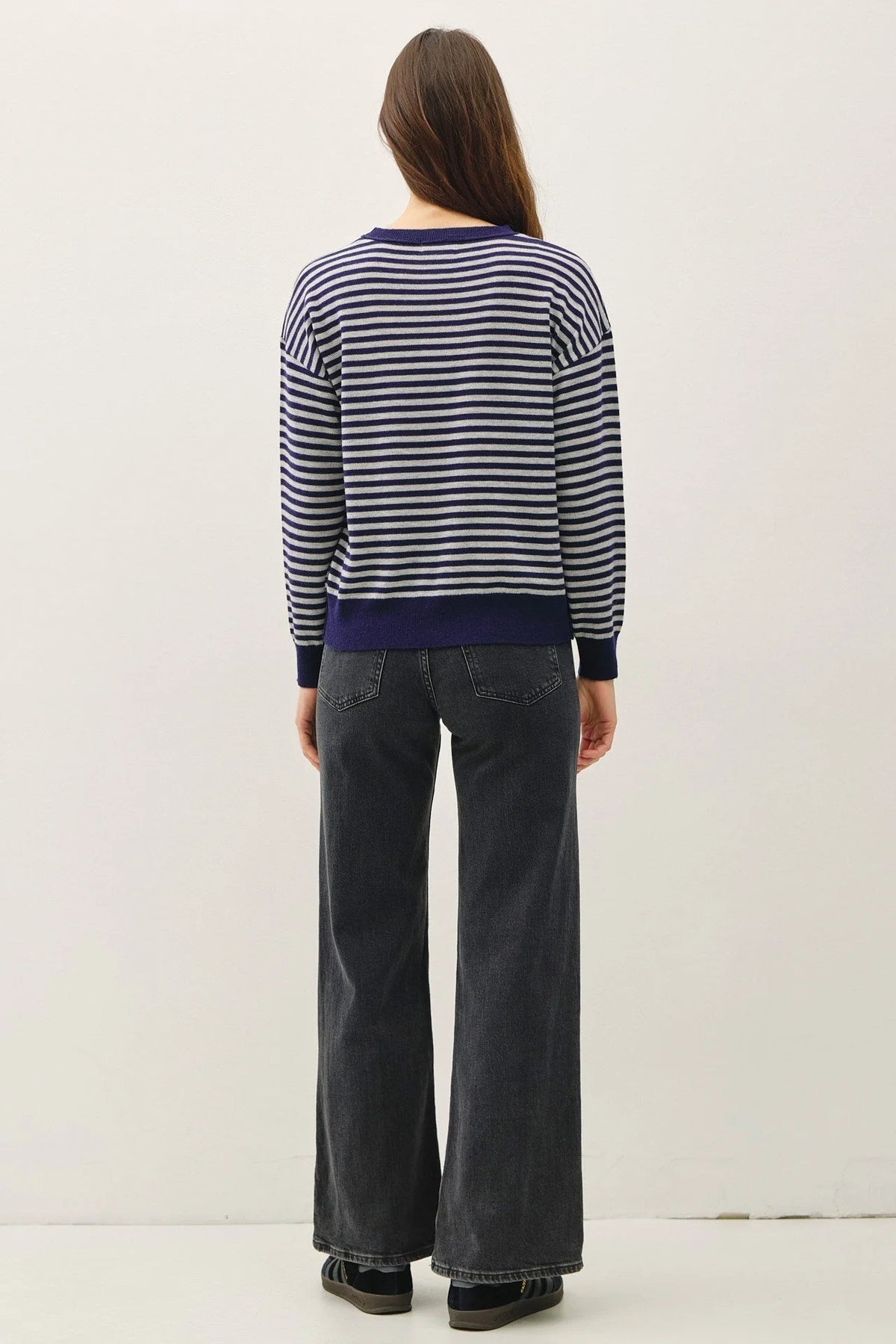 Women’s wool blended striped sweater top with navy and white stripes and dark wash jeans