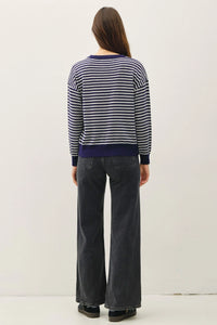 Women’s wool blended striped sweater top with navy and white stripes and dark wash jeans