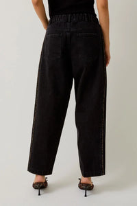 Women’s loose-fit black jeans with leopard print piping and visible white stitching