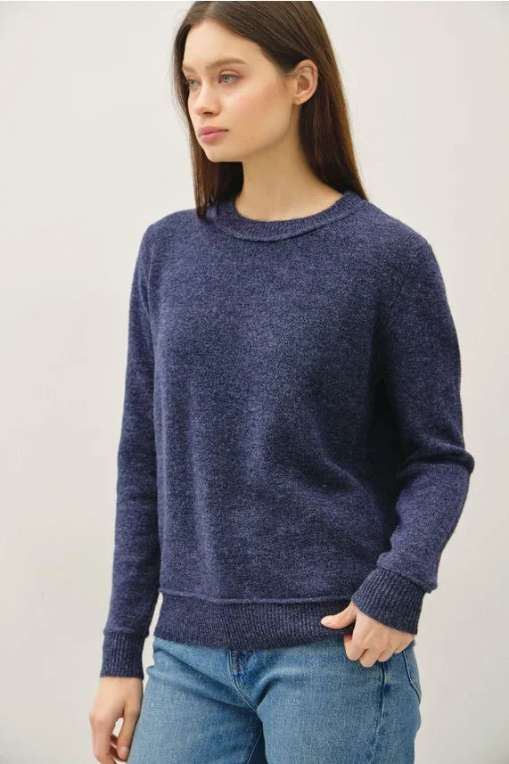 Women’s navy blue crew neck pullover with exposed seams, subtle marled texture, and ribbed cuffs