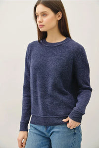 Women’s navy blue crew neck pullover with exposed seams, subtle marled texture, and ribbed cuffs