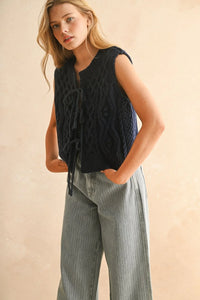 Women’s navy blue cable knitted vest with tie-front design, perfect for layered fashion