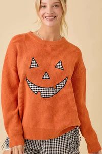 Women’s orange knitted Pumpkin Face Patchwork Sweater with black and white gingham accents