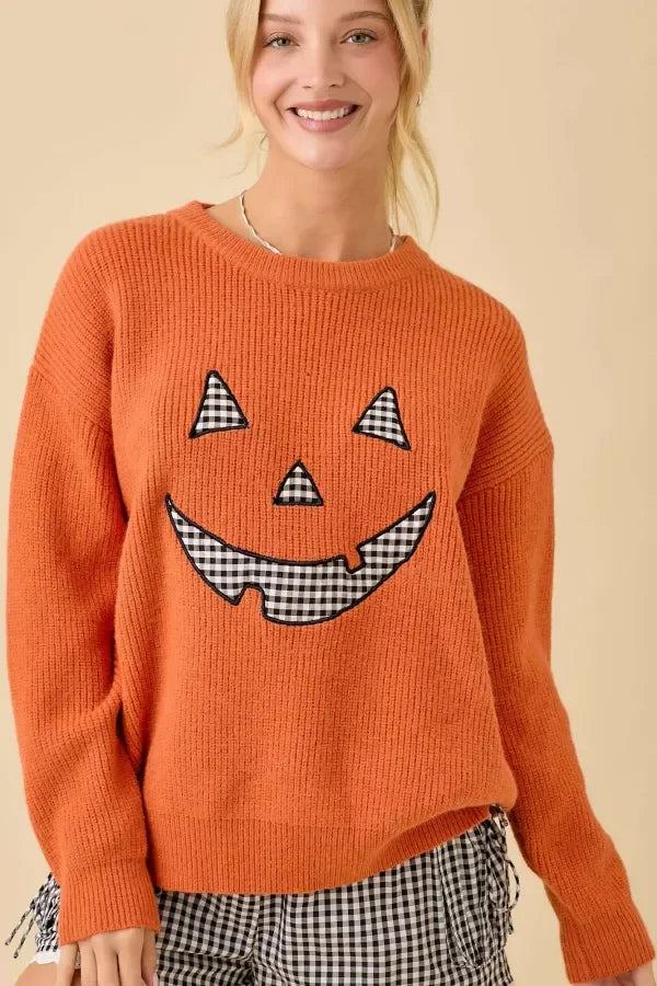 Women’s orange knitted Pumpkin Face Patchwork Sweater with black and white gingham accents