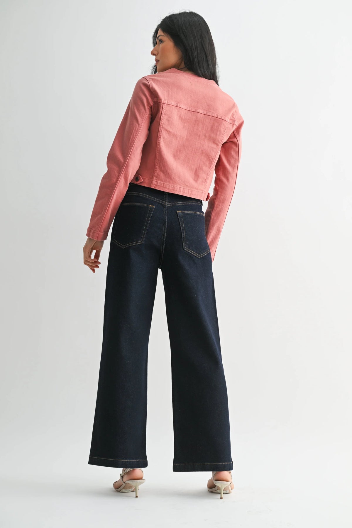 Women’s pink cropped denim jacket with patch pockets paired with dark wash wide-leg denim jeans