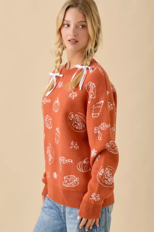 Women’s terracotta-colored pumpkin spice printed sweater with white autumn designs and shoulder ties