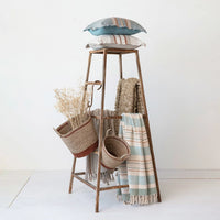 Wooden ladder-style shelf showcasing a woven cotton throw with stripes and fringe