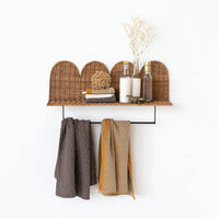 Woven rattan wall shelf with hooks for hanging cotton knit tea towels underneath