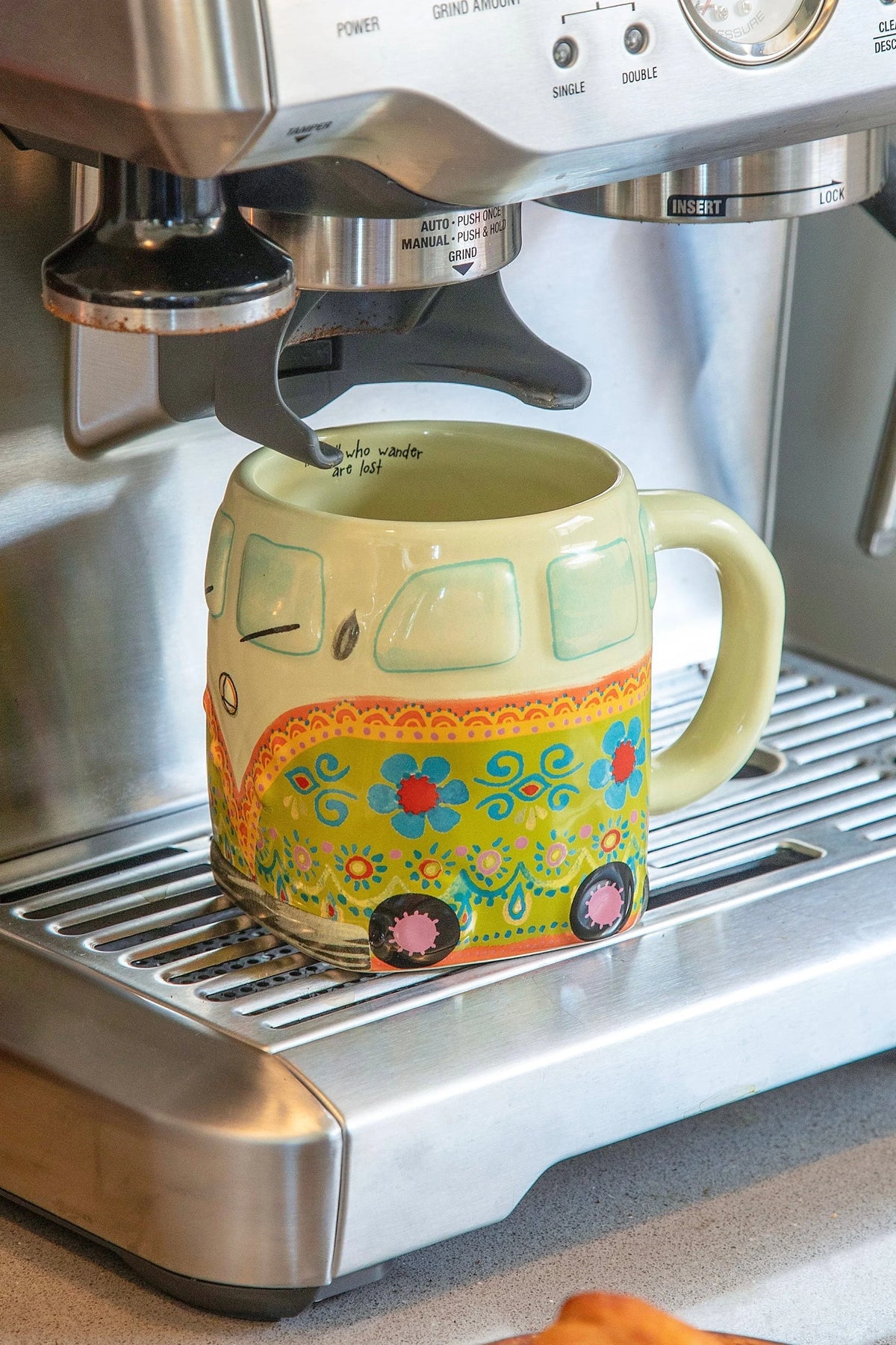 Yellow ceramic mug featuring colorful floral and wheel pattern, ideal for folk art coffee