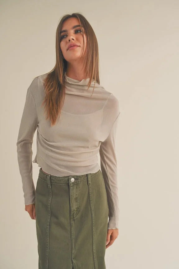 Young woman in beige turtleneck and olive green skirt wearing Women’s Boho Chic Clothing