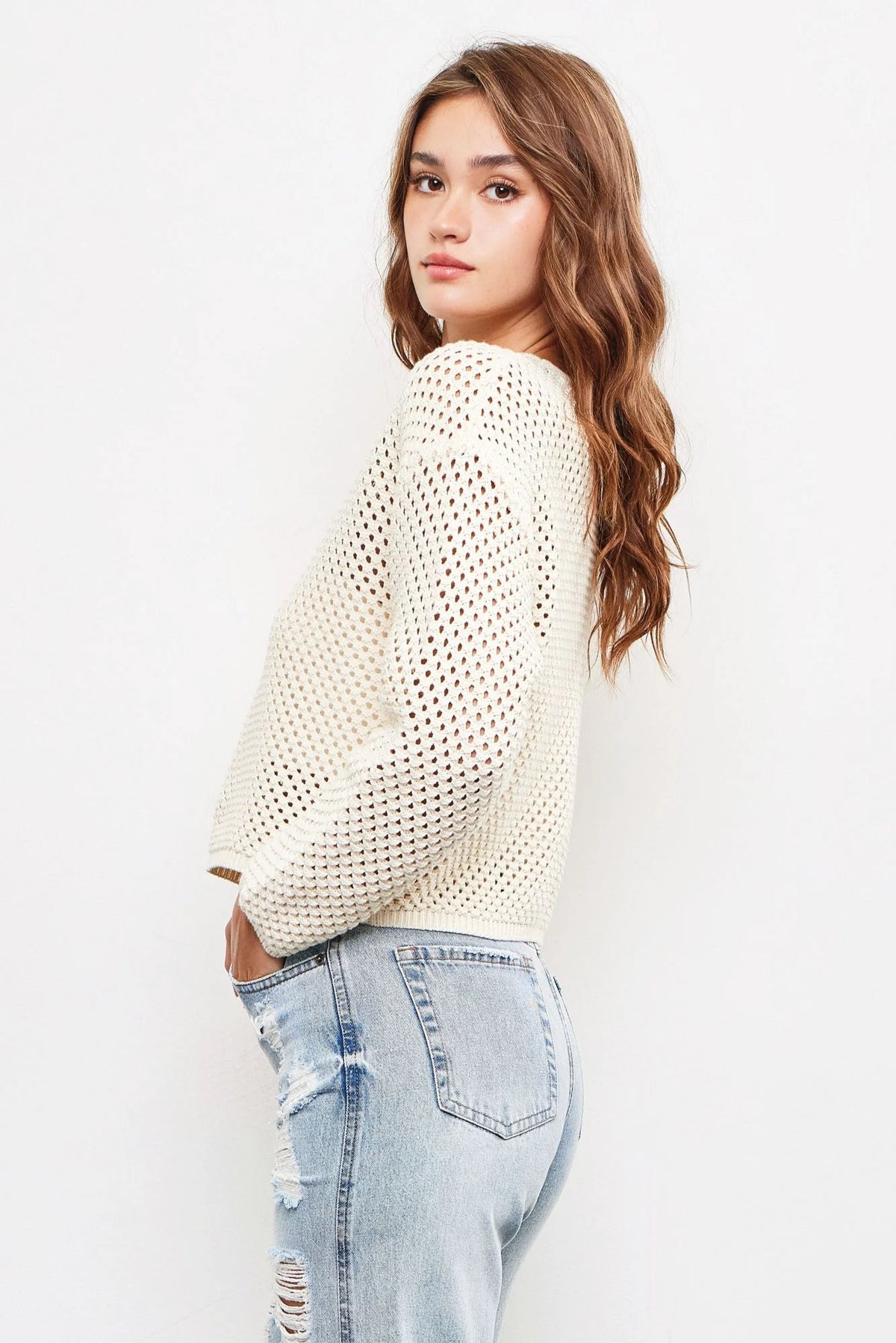 Young woman in cream knit sweater and distressed jeans from shop Daisy, size small, boho chic