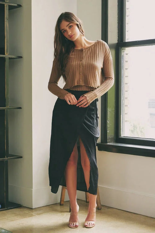 Young woman in cropped sweater and black skirt showcasing Shop Daisy women’s boho clothes