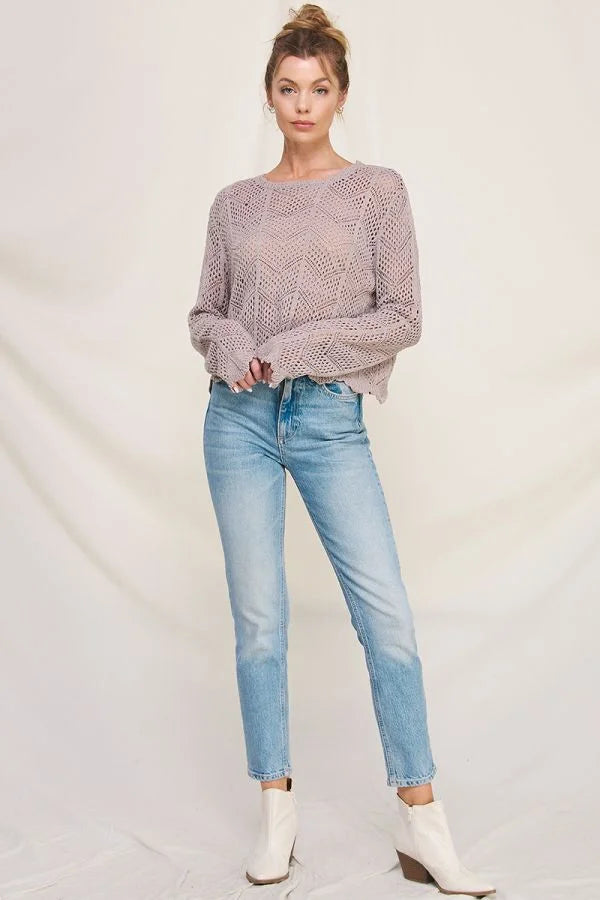 Young woman in lavender long sleeve chevron pointelle sweater and light blue jeans