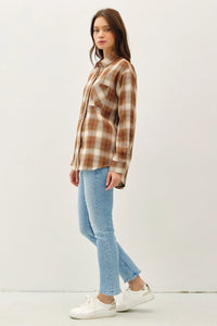 Young woman in plaid shirt and jeans showcasing the Classic Oversized Flannel Top