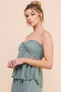 Young woman in a flowy sage green crinkled woven dress showcasing boho style