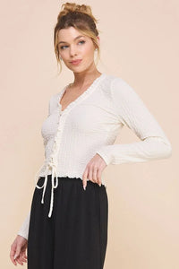 Young woman in a crinkled woven long sleeve lace up top from Shop Daisy