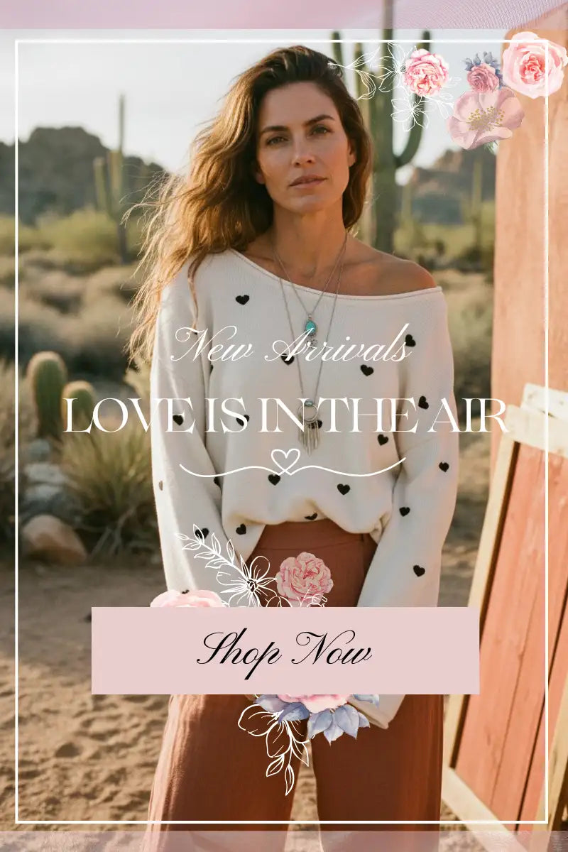 White off-the-shoulder sweater with black heart patterns