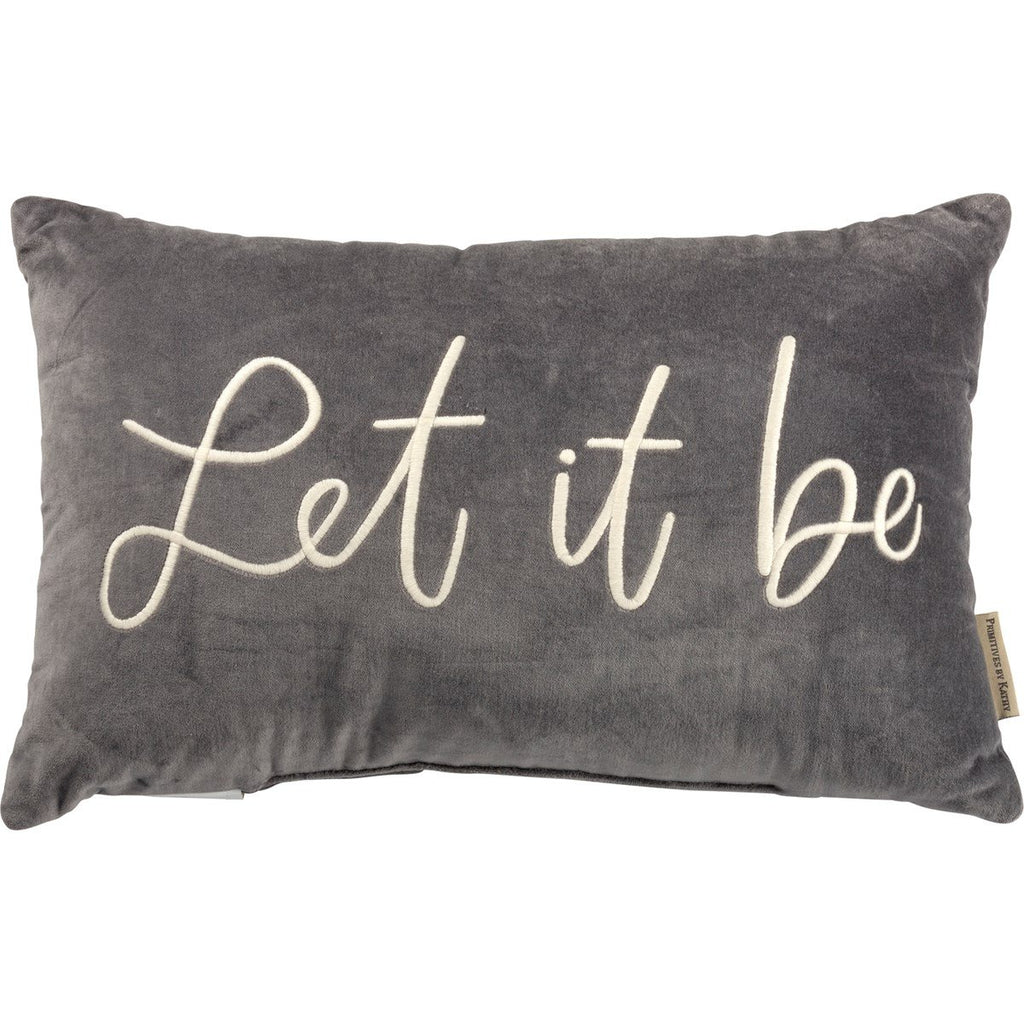 Gray velvet pillow featuring "Let it be," in cursive lettering.