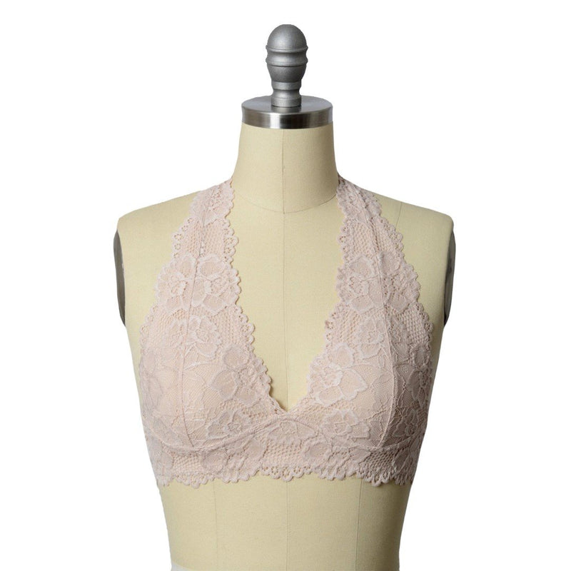A mannequin wearing a blush, lace, halter top bralette.